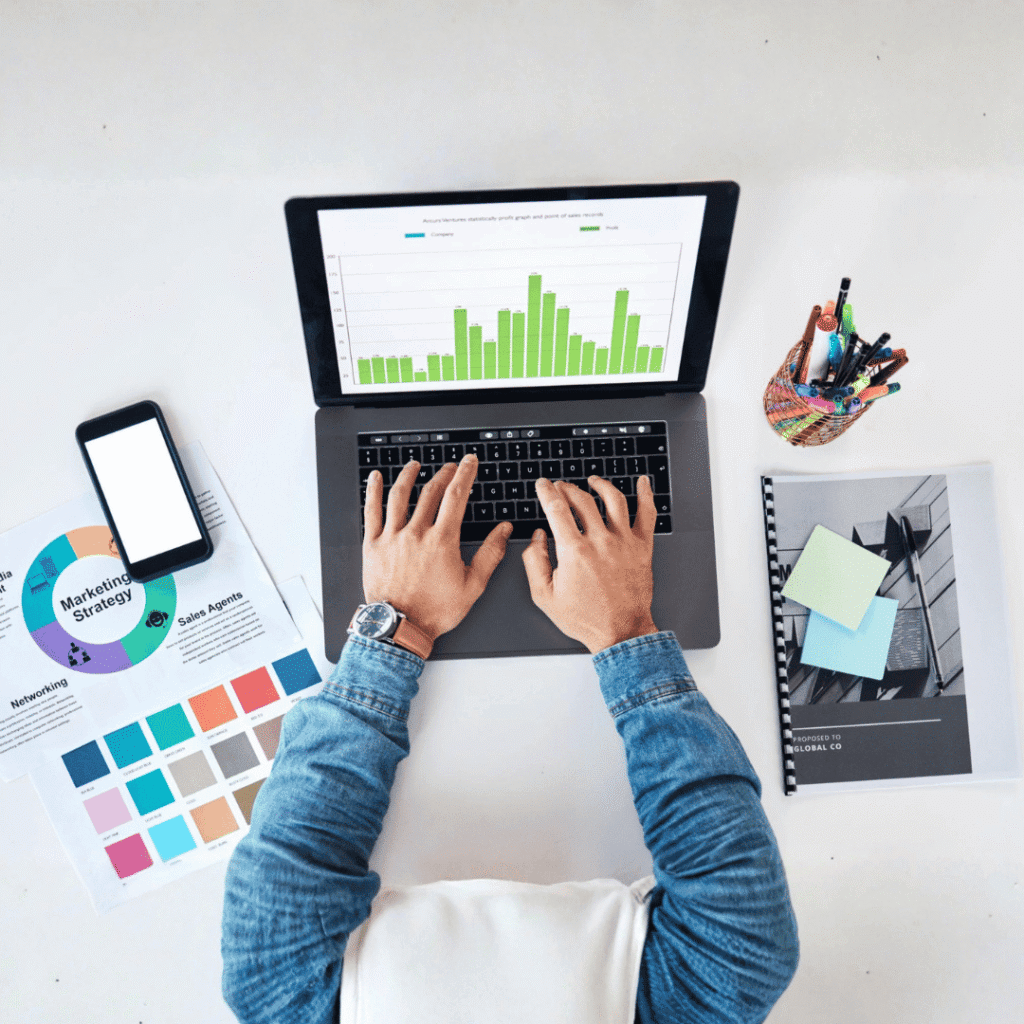 US digital marketing research and analysis showing laptop with analytics data, keyword strategy documents, and planning materials