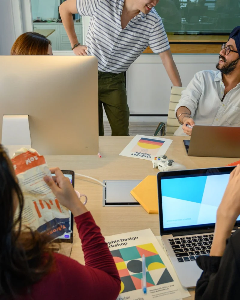 Professional digital marketing team collaborating around a laptop at Zenvex Digital Solutions