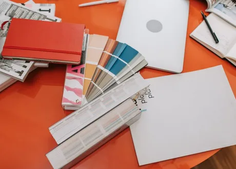 Colour swatches and design references laid out across a studio desk
